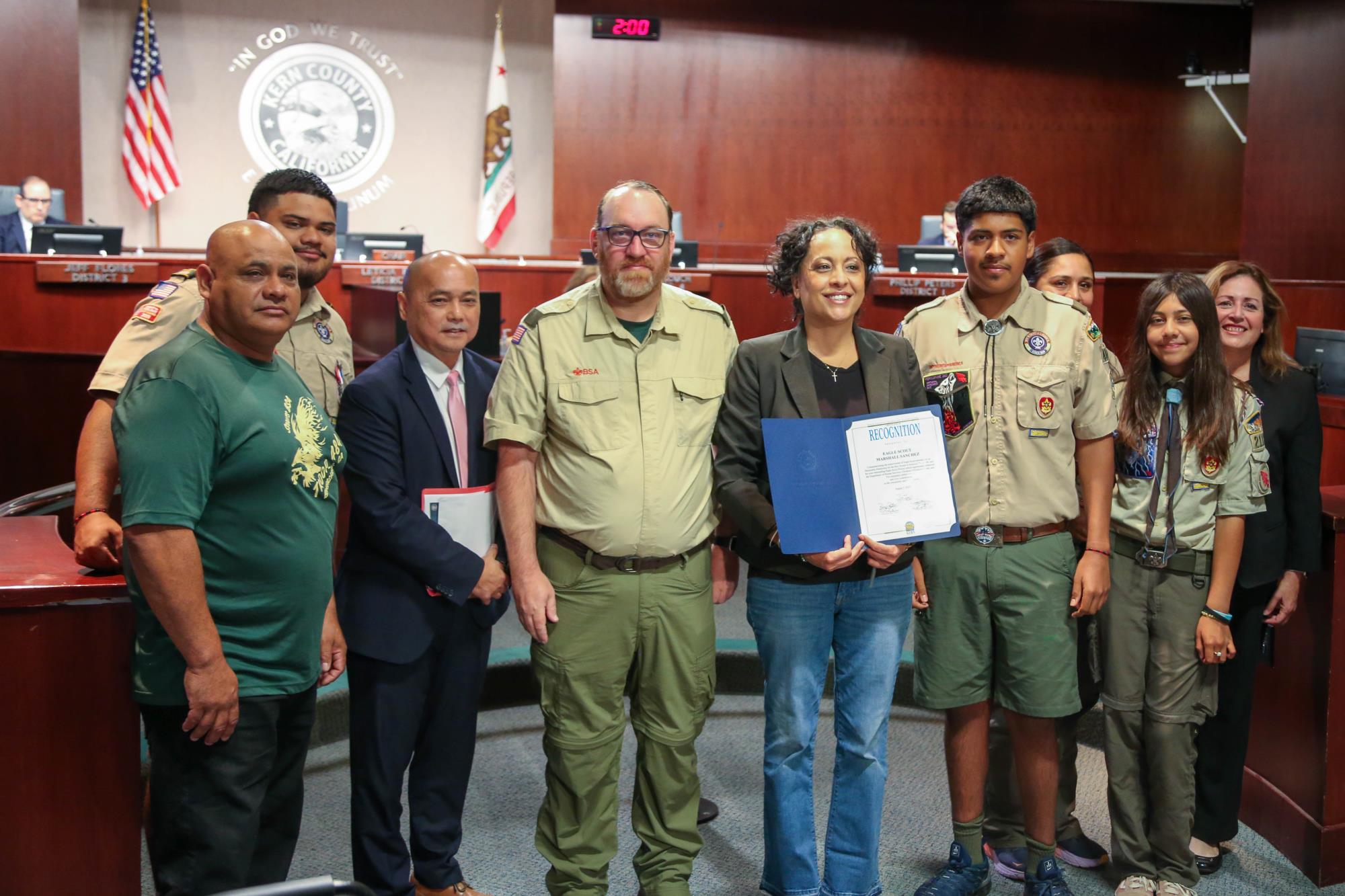 photo of Fifth District Supervisor Leticia Perez presenting a certificate of recognition to a local Boy Scout for his work to improve the playground at the Department of Human Services