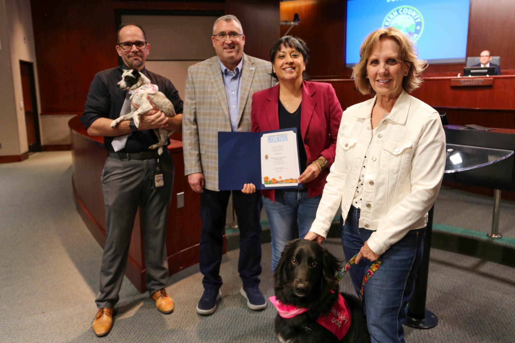 Photo of Supervisor Perez, Nick Cullen, Bill Lamanque, and therapy dog, Nick and her owner Jackie for a proclamation for National Therapy Animal Day in Kern County